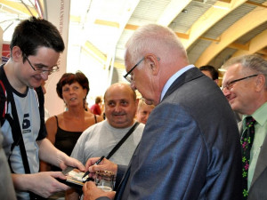 Prezident Václav Klaus během setkávání s návštěvníky výstavy podepisoval fotografie ( a propisky poctivě vracel)