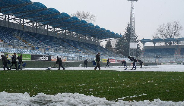 Odklízení sněhu na ploše hlavního stadionu na Střeleckém ostrově je v plném proudu