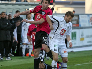 Vzdušný souboj Michala Klesy s Jiřím Poděbradským, v pozadí čtvrtý rozhodčí signalizuje tři minuty nastavení