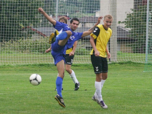Rudolfovský stoper Kamil Gažák odkopává míč před Martinem Tomanem z Dačic. Foto Milan Šíma, www.jihoceskyfotbal.z