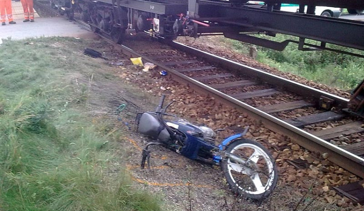 Motocykl ženy, která vjela pod vlak