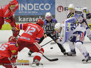 Čárový rozhodčí Skopal háže puk mezi hokejky Kotalíka a Koreise