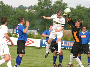 Kapitán Roudného Libor Matoušek hlavičkuje před gólmanem Ramsem při jihočeském derby s Čížovou. Foto: Milan Šíma, www.jihoceskyfotbal.cz