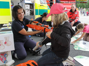 Tisková mluvčí HZS Jihočeského kraje Petra Kafková předvádí dětem, jak zraněnému zafixovat zlomenou ruku