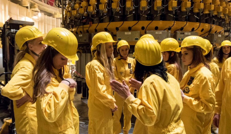 Na reaktorovém sále dívky poslouchají výklad před zařízením, které slouží k utahování víka reaktoru