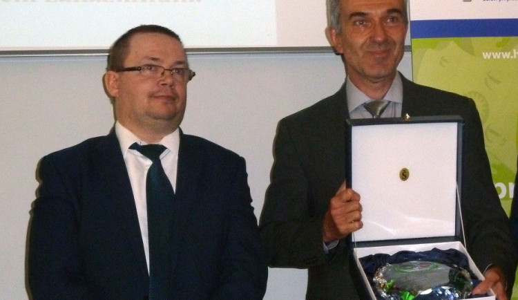 Miroslav Houfek s oceněním Bezpečný podnik, které mu předal vedle stojící Jiří Vaňásek, náměstek ministryně práce a sociálních věcí