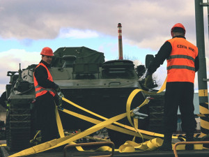 Vojáci zajišťují pásové vozidlo pomocí upevňovacích popruhů.