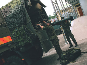 Nakládání materiálu na jedno z vozidel.