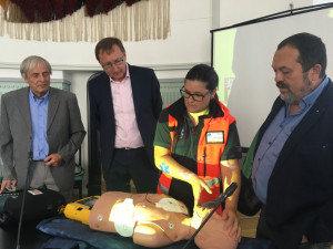 Zleva František Lust z Nadace ČEZ a Jan Kruml, ředitel JE Temelín sledují jak správně použít defibrilátor