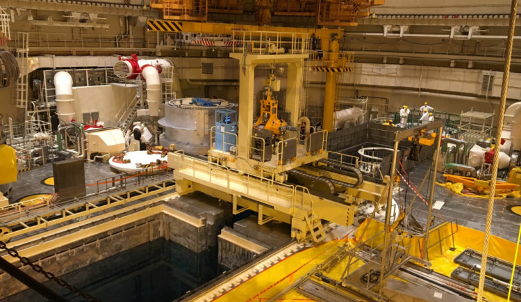 Manipulace s palivem mezi reaktorem a vedlejším bazeném se dějí pomocí dálkově ovladaného zavážeciho stroje