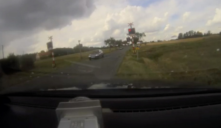 Červená na železničních přejezdech není pro řidiče zeď. Policisté natočili riskantní jízdu