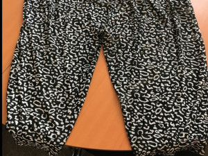 Na sobě měla tmavé vzorované kalhoty.