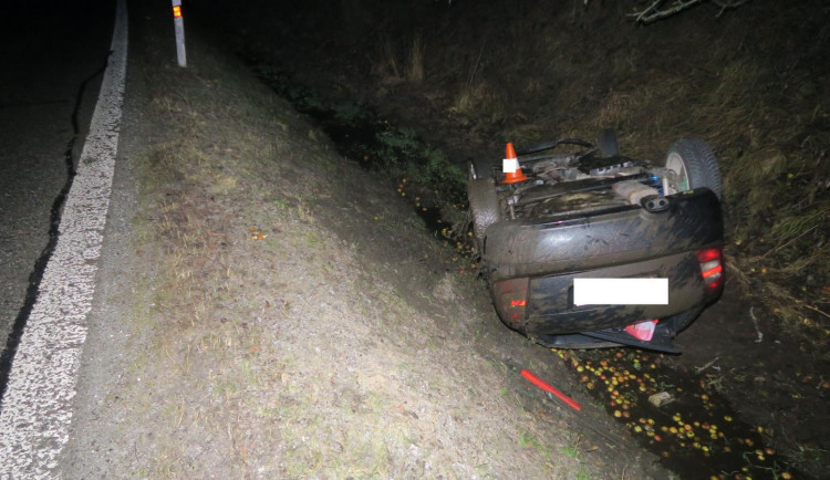 Řidič dostal na mokré silnici smyk a narazil do stromu. Auto zůstalo po nárazu na střeše