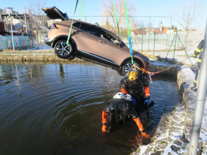 Žena sjela autem do požární nádrže. Vůz museli vytáhnout hasiči jeřábem