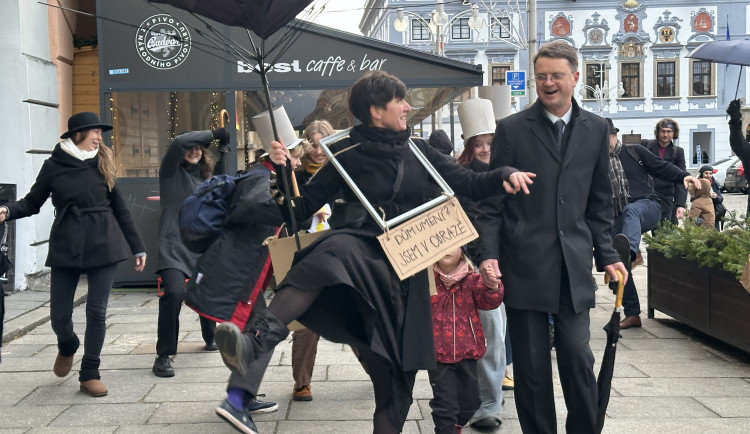 Černý kostým, kufřík a buřinka. Delegace z Ministerstva švihlé chůze prošla centrem Českých Budějovic