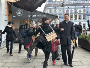 Černý kostým, kufřík a buřinka. Delegace z Ministerstva švihlé chůze prošla centrem Českých Budějovic