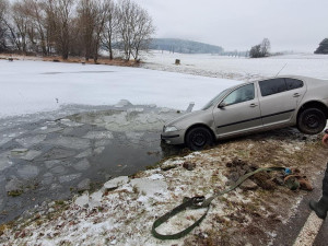 Řidič dostal na ledovce smyk a skončil s autem v rybníce. Silnice mohou namrzat i v noci na čtvrtek