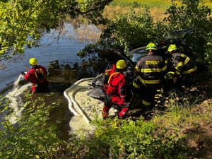 Auto sjelo do rybníka. Hasiči zachránili řidičku i psa