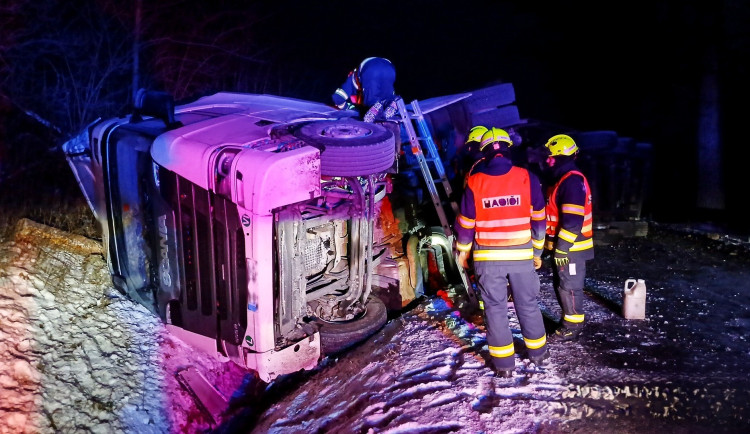 Kamion se převrátil na bok, řidič utrpěl zranění. Silnice je neprůjezdná