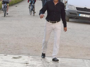 Přichází. Tvář ustaranou, unavený krok