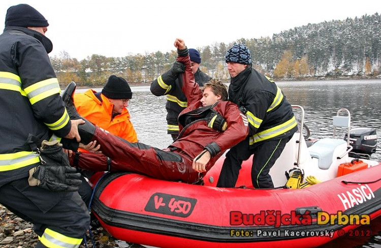 Cvičení potápěčů na římovské přehradě. Hasiči dostávají Václava Svobodu z člunu na nosítka