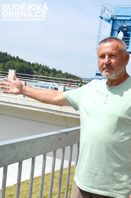 Daniel Barcal ukazuje na korunu hráze, přes kterou vede most do Přední Výtoně