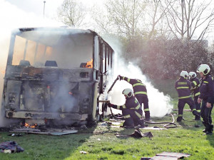 Požár vraku autobusu na louce u Vltavy v Českých Budějovicích