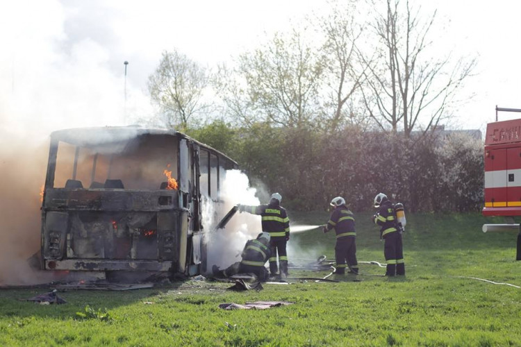 Požár vraku autobusu na louce u Vltavy v Českých Budějovicích