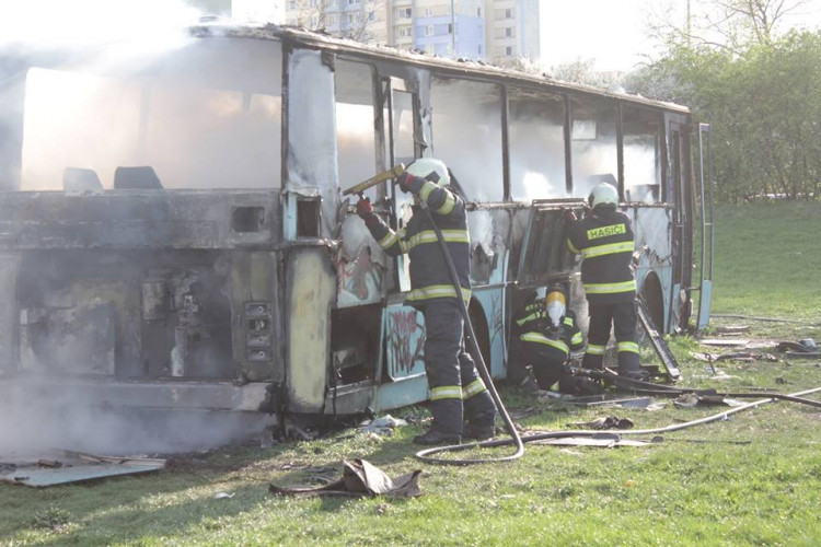 Požár vraku autobusu na louce vuVltavy v Českých Budějovicích