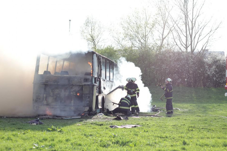 Požár vraku autobusu na louce u Vltavy v Českých Budějovicích
