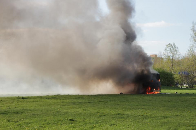 Požár vraku autobusu na louce u Vltavy v Českých Budějovicích