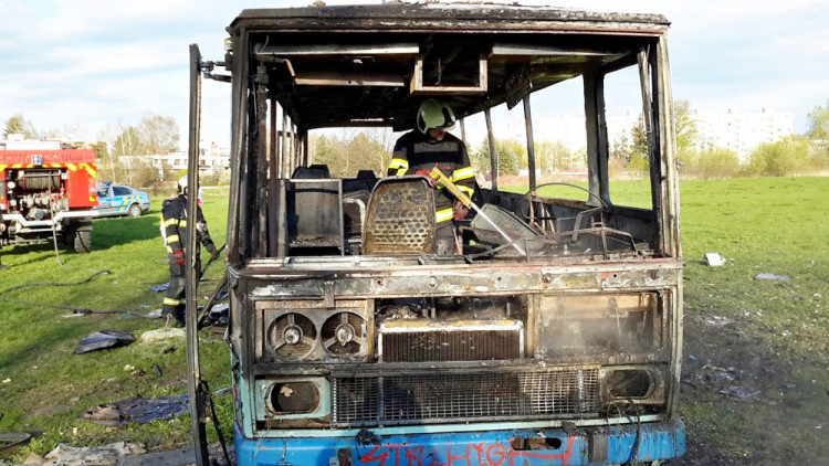 Požár vraku autobusu na louce u Vltavy v Českých Budějovicích