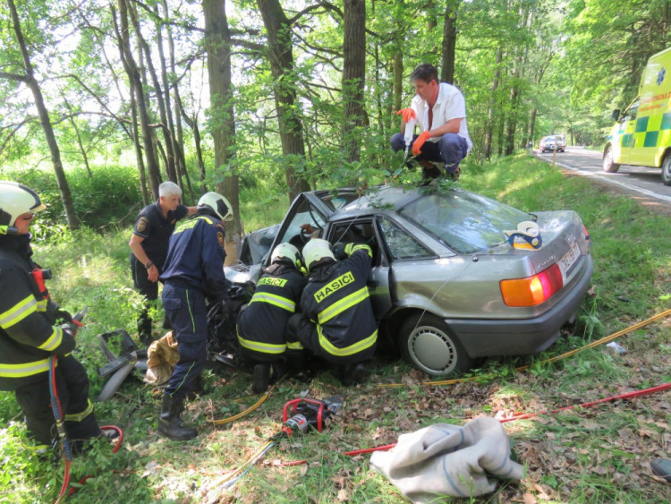 Nehoda se stala loni v létě na silnici mezi obcemi Římov a Plav, kde narazil osobní automobil Audi 80 do stromu a začal hořet. Nárazem se zaklínily dveře řidiče, který se tak nemohl dostat ven. Pomohl mu statečný student Jan Jirka.