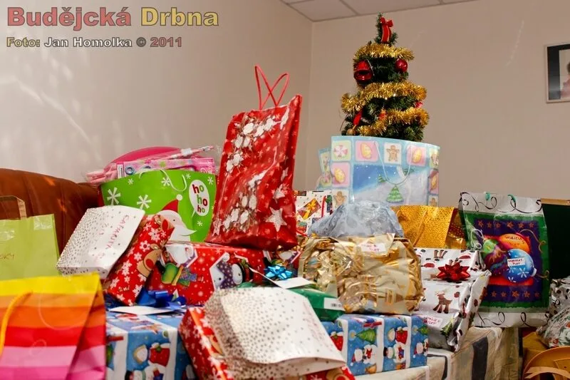 Vánoční stromek vyvyšující se nad záplavou dárků