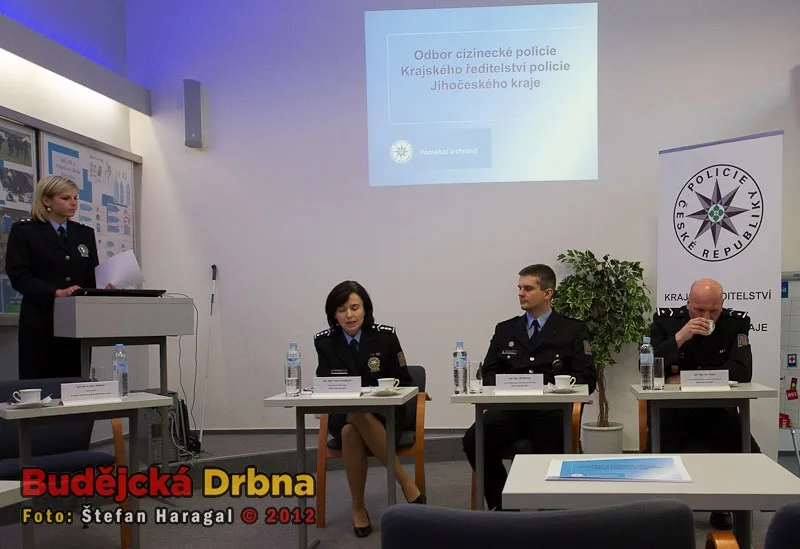 Zástupci cizinecké policie na tiskové konferenci. Zleva plukovník Ivana Zelenáková, major Jiří Stuchlý a major Jan Vrátný, stojí tisková mluvčí poručík Lenka Holická