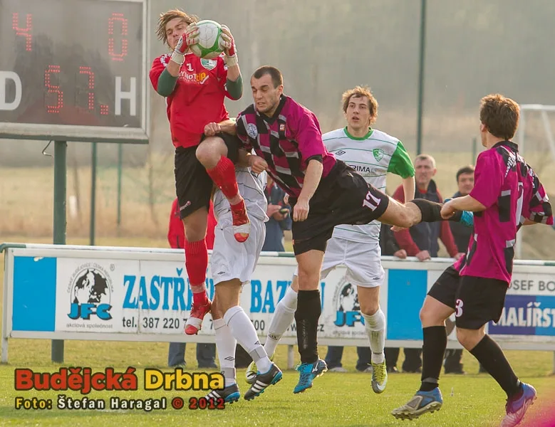 Brankář Roudného Jiří Komrska v akci, atakovaný Lukášem Dudkem