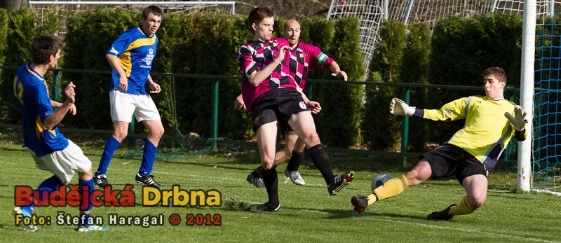 Karel Voldán (zcela vlevo) střílí jedinou branku utkání Hluboká - Jindřichův Hradec. Janeček i brankář Brašnička byli na jeho střelu krátcí