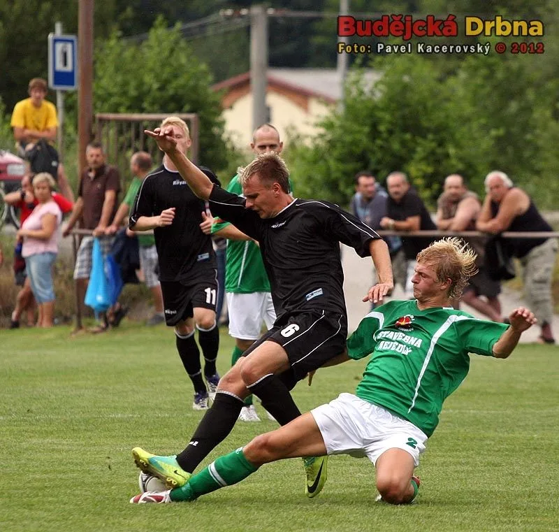 Domácí zadák Jakub Wagner se snaží skluzem zastavit Františka Němce