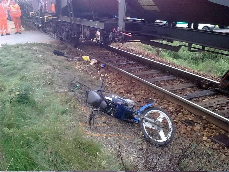 Motocykl ženy, která vjela pod vlak