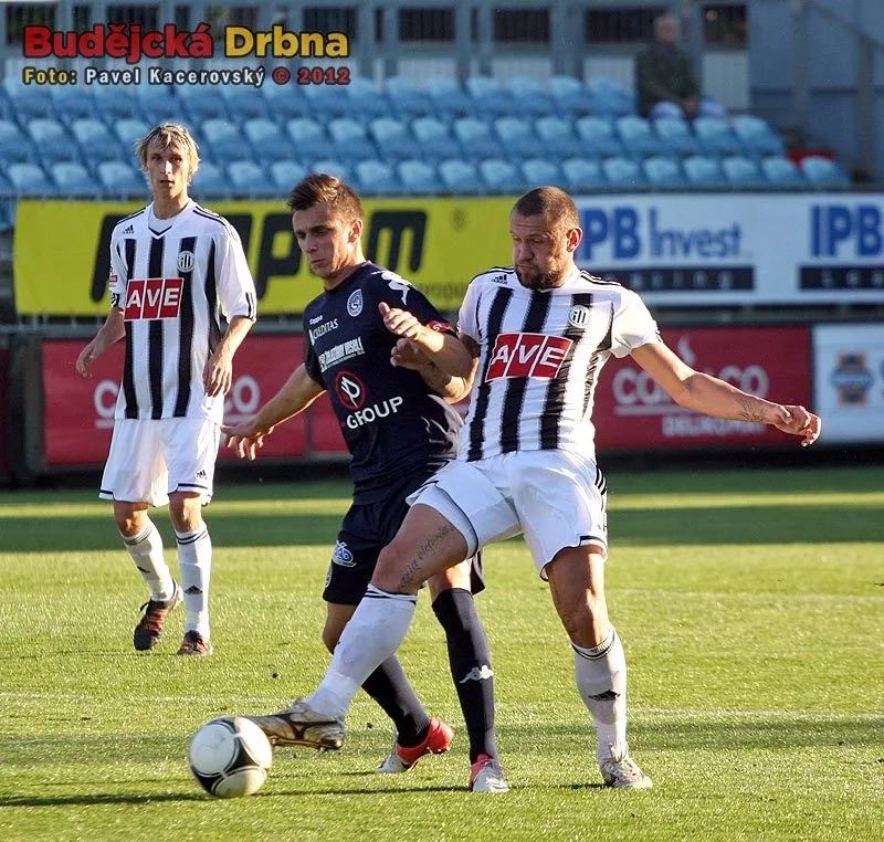 Stoper Dynama Jan Halama odehrává míč před Mariánem Kovářem