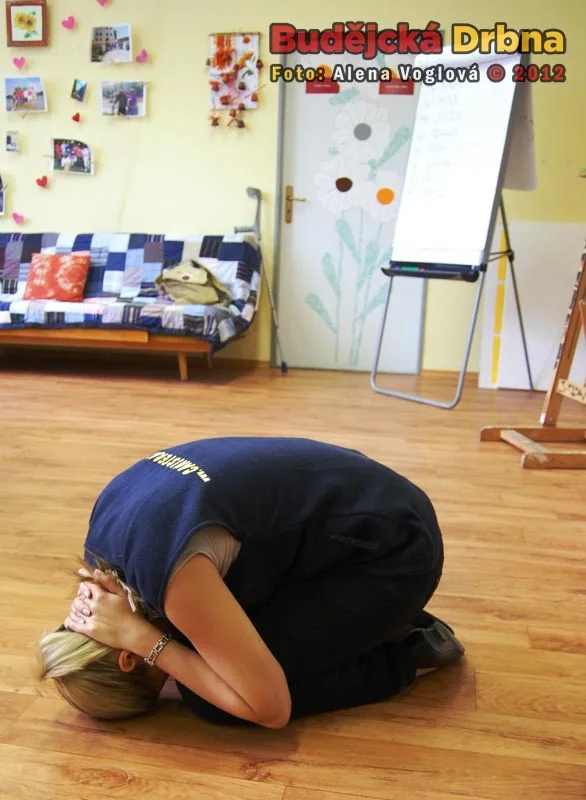 Katka předvádí pozici želvy, která se má zaujmout, když se na vás řítí rozzuřený velký pes