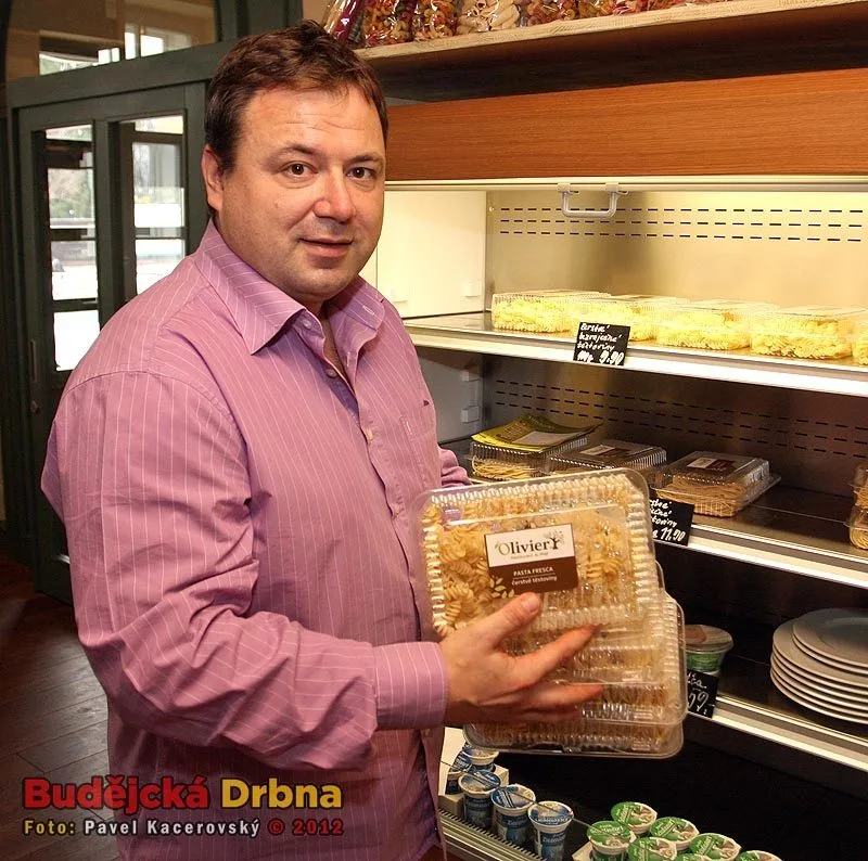 Šéfkuchař restaurace Olivier Robert Burian drží plastové vaničky, v nichž si můžete čerstvé těstoviny zakoupit v sousedním obchodě