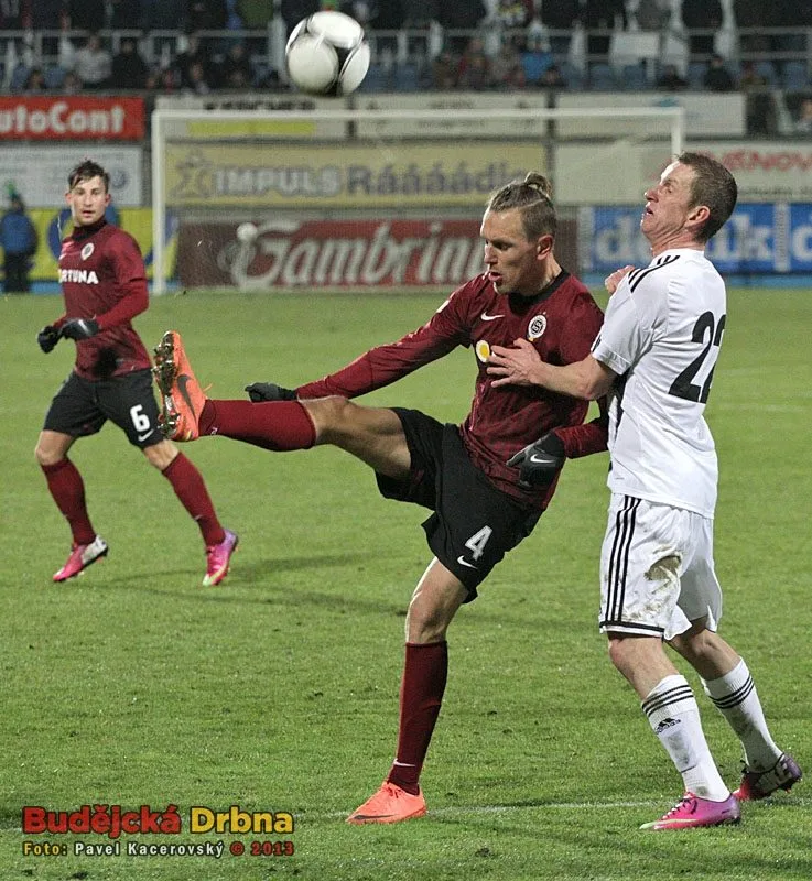 Hostující Ondřej Švejdík odkopává balon před Petrem Benátem