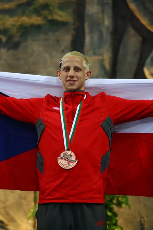 Jan Chaloupka se na stupních vítězů raduje z bronzové medaile