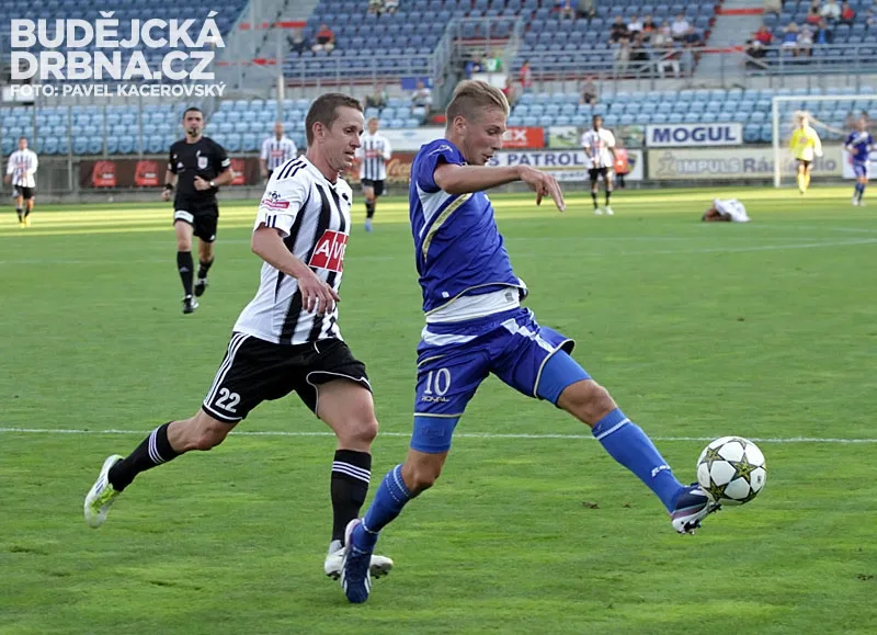 Jan Peterka odkopává míč před Petrem Benátem