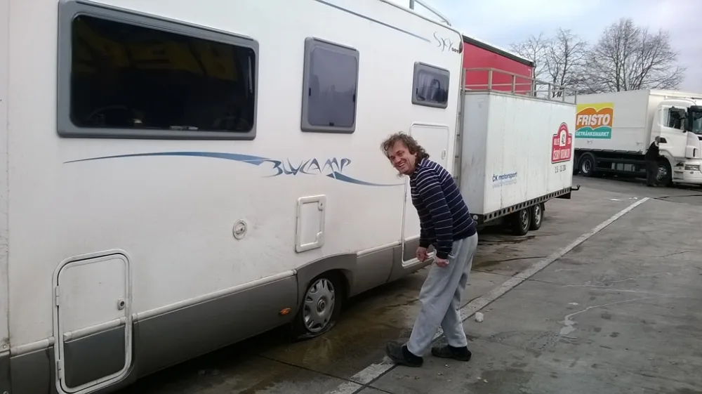 Defekt kola u obytného vozu při cestě do Francie. Na snímku mechanik Marcel Tuček. Foto Jan Bláha