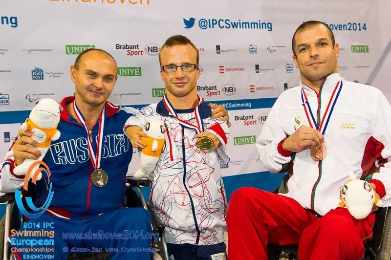 Arnošt Petráček (uprostřed) se zlatou medailí z disciplíny 50 metrů znak