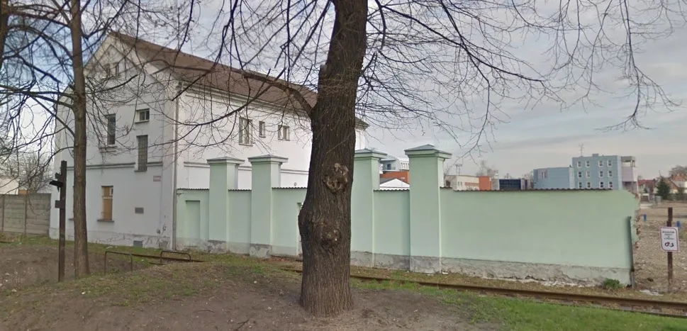 Stará administrativní budova a zbytek obvodové zdi