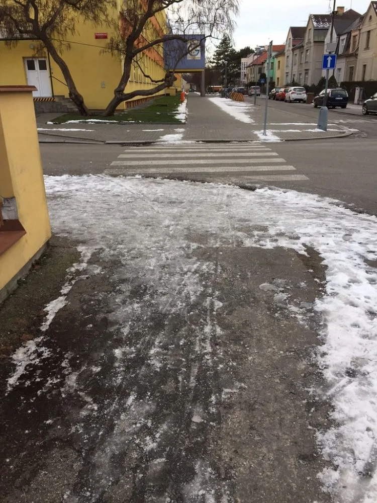 Zmrzlý sníh na chodníku u ZŠ Grünwaldova