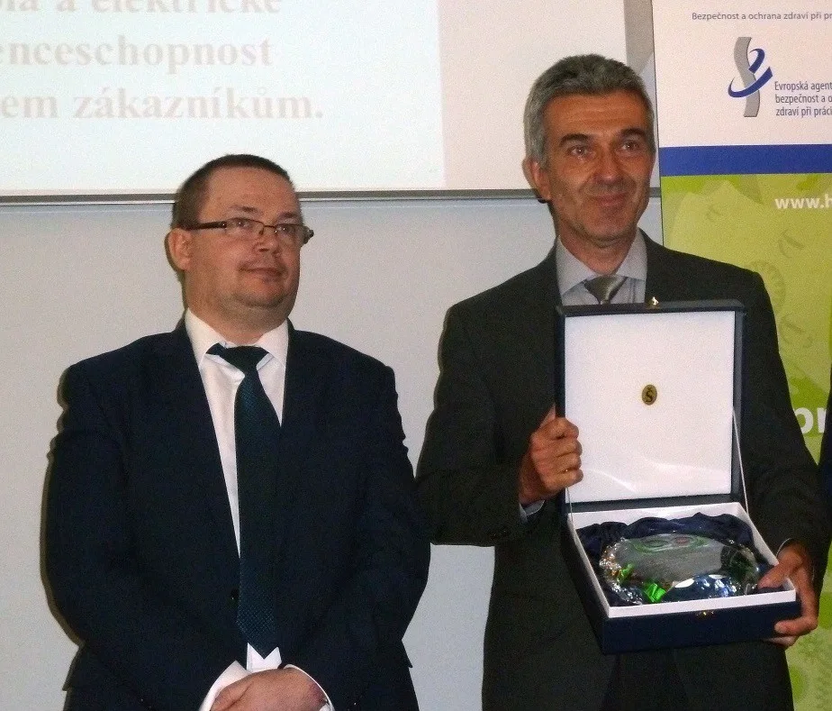 Miroslav Houfek s oceněním Bezpečný podnik, které mu předal vedle stojící Jiří Vaňásek, náměstek ministryně práce a sociálních věcí